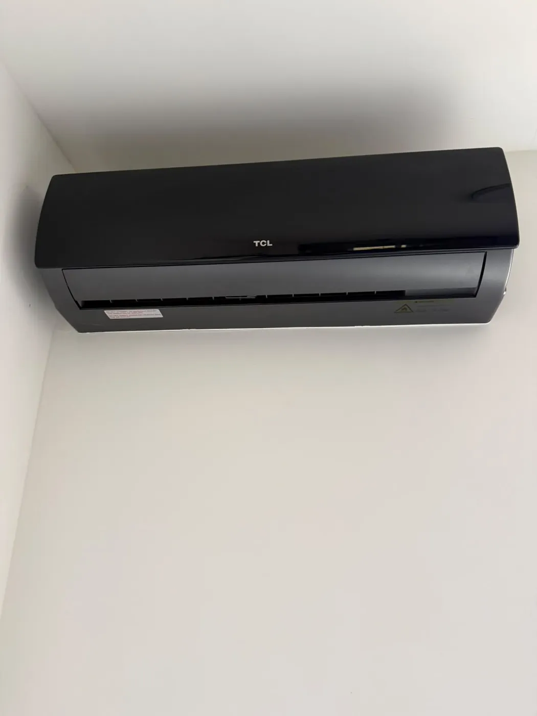 Zwarte airco binnenunit geplaatst in een woning
